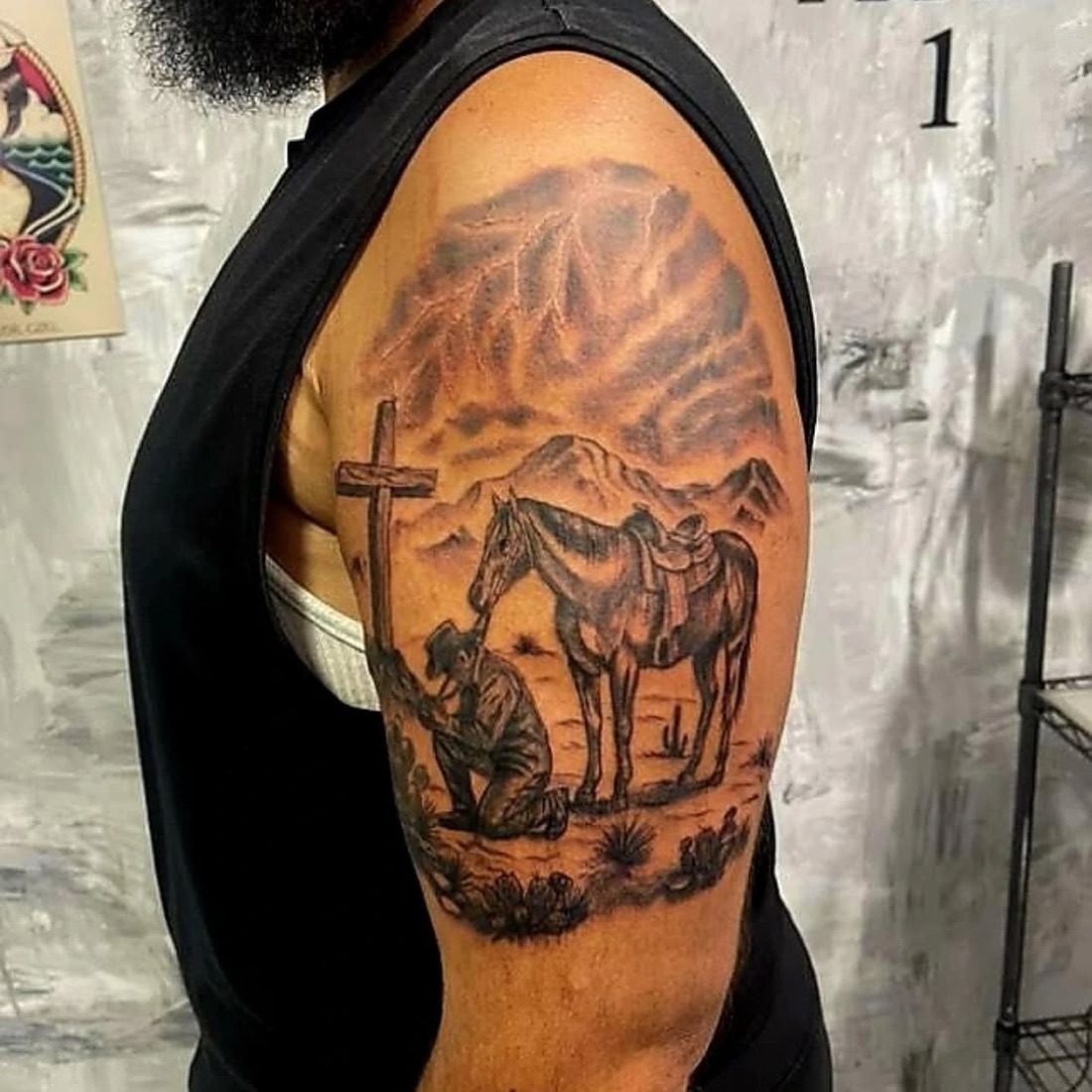Tatuagem em preto e cinza de um guerreiro com cavalo no braço